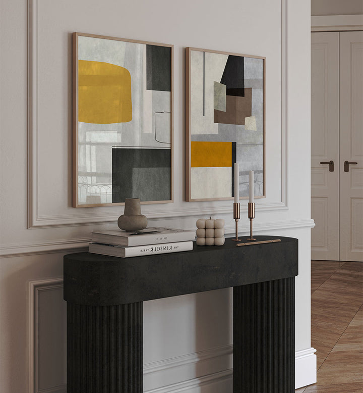 Two abstract paintings on a wall above a fireplace with decorative items.