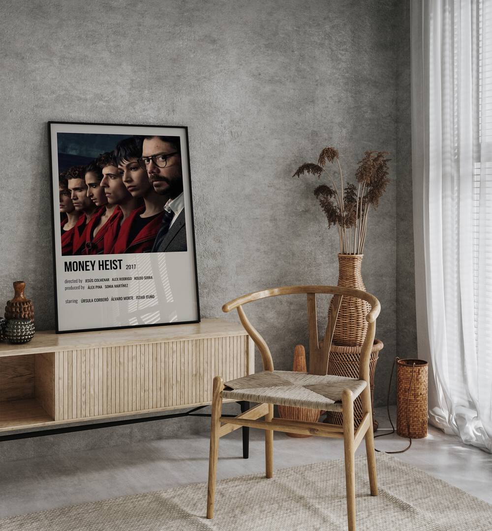 Money Heist 2017 I Movie Posters in Black Plain Frame placed on a table beside oakwood chair