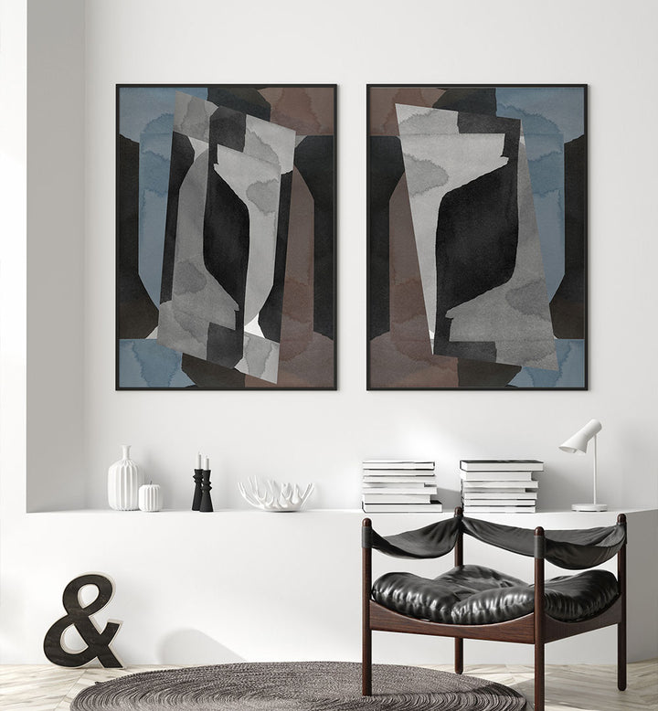 Two abstract artworks on a wall above a white shelf with decorative items.