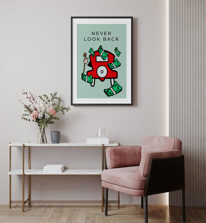 Never Look BAck Money Art ARtwork in black frame with mount hainging on wall above red chair