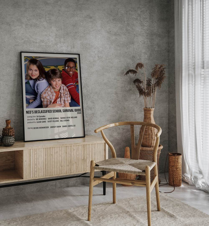Neds Declassified School Survival Guide 2004 Movie Posters in Black Plain Frame placed on a table beside oakwood chair