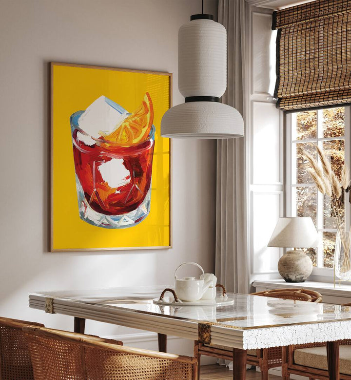 Negroni on Sunshine by Alice Straker Bar Posters Bar Art Prints in Oak Wood Plain Frame placed on a wall in a dining room area beside a window and behind a dining table