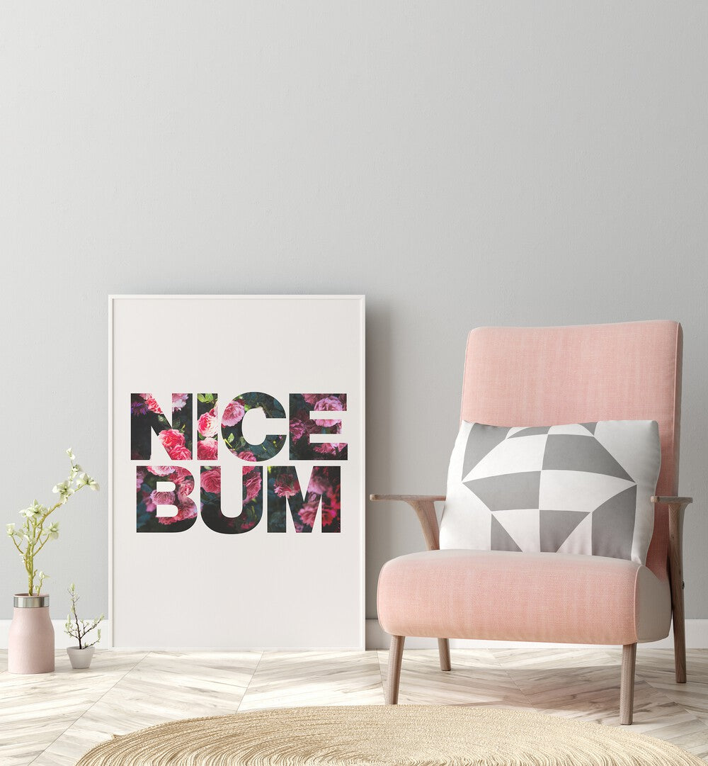 Nice Bum By Sarah Manovski Quotes and Typography Poster in White Plain Frame placed on a floor beside a chair