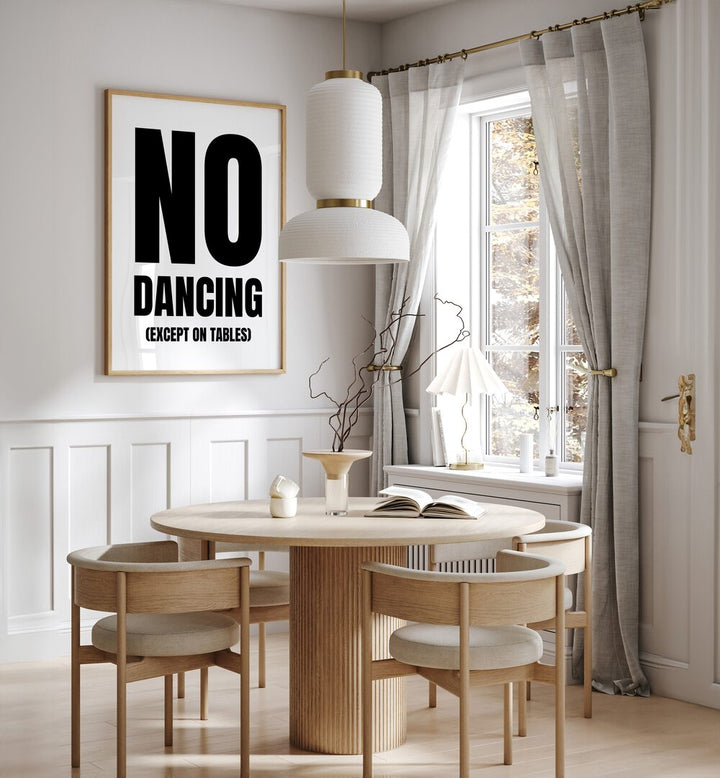 No Dancing by Athene Fritsch Quotes and Typography Posters in Oak Wood Plain Frame placed on a wall in a dining room area beside a window and behind a dining table