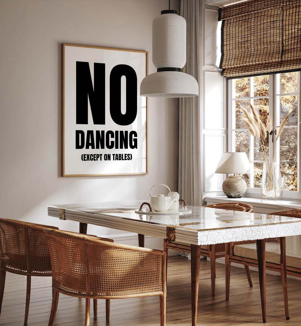 No Dancing by Athene Fritsch Quotes and Typography Posters in Oak Wood Plain Frame placed on a wall in a dining room area beside a window and behind a dining table