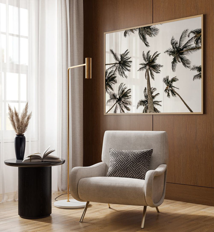 Noir Nirvana Beach Prints Coastal Wall Art in Oak Wood Plain Frame placed on a wall behind a chair