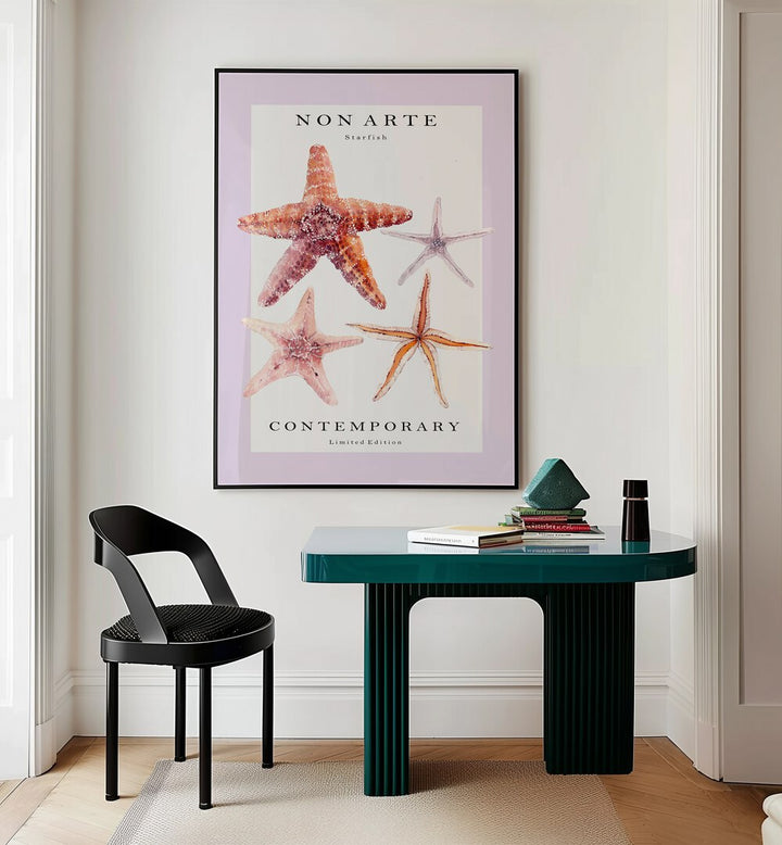 Non Arte Starfish By Rikke Londager Boisen Beach Prints in Black Plain Frame placed on a Cream Colored Wall near a Workspace Table in the Drawing Room