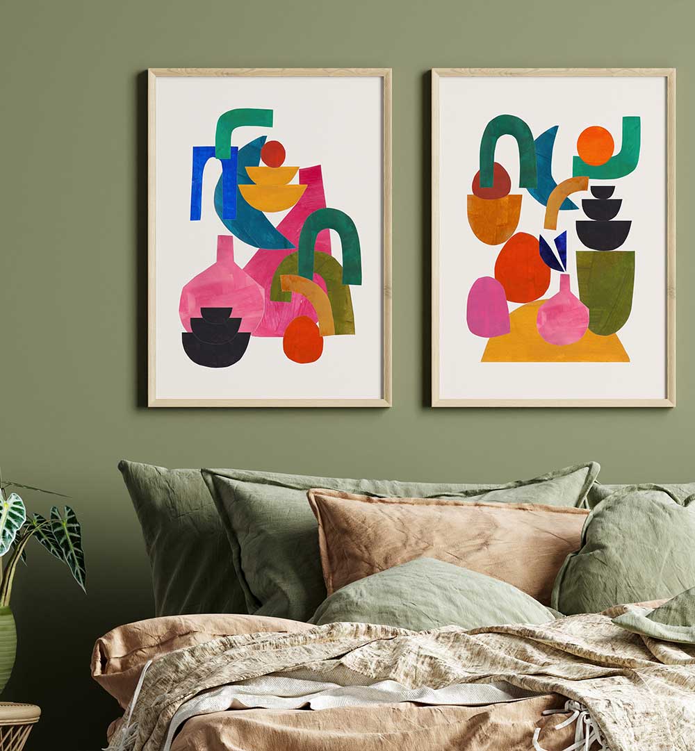 Two colorful abstract artworks on a green wall above a sofa with patterned cushions.