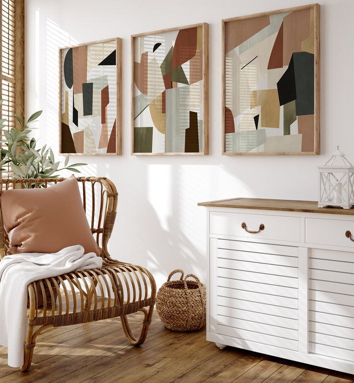 Nordic Shapes Set Set Of 3 Paintings in Oak Wood Plain Frame placed on a wall behind a chair