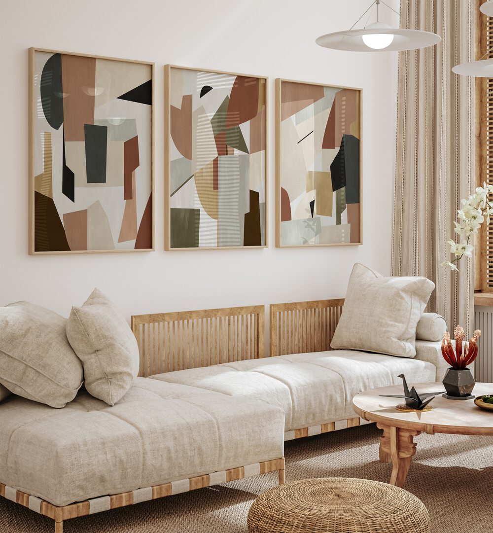 Nordic Shapes Set Set Of 3 Paintings in Oak Wood Plain Frame placed on a living room wall behind a sofa