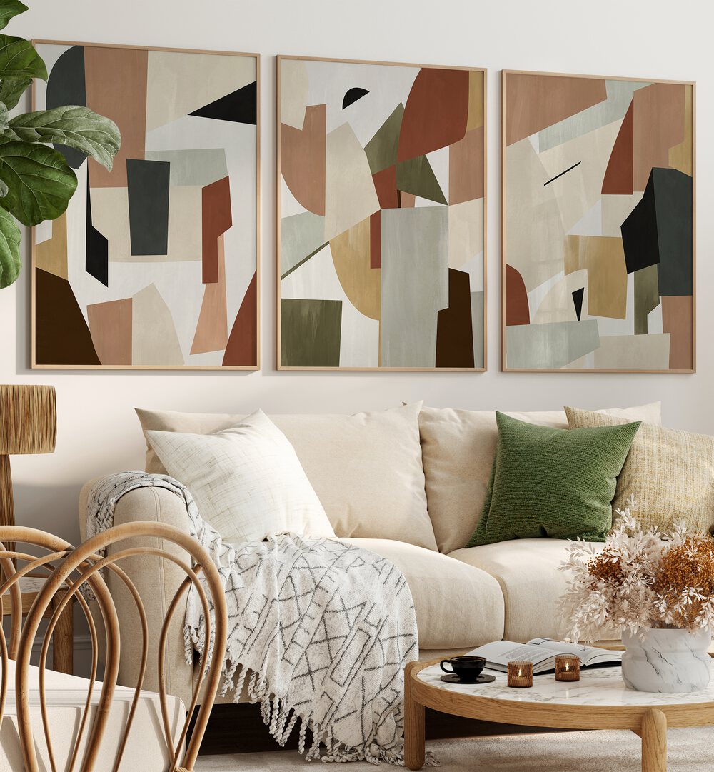 Nordic Shapes Set Set Of 3 Paintings in Oak Wood Plain Frame placed on a living room wall behind a sofa