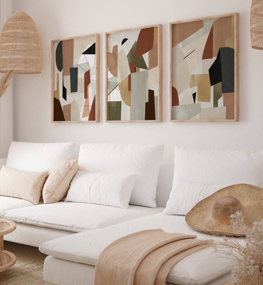 Nordic Shapes Set Set Of 3 Paintings in Oak Wood Plain Frame placed on a living room wall behind a sofa