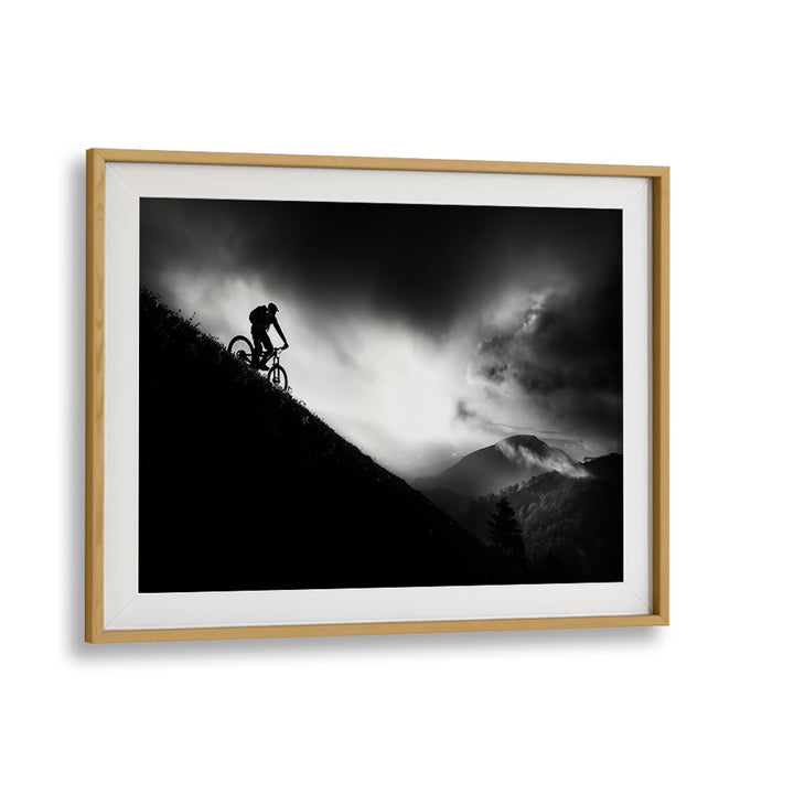 Silhouetted cyclist conquering a mountain at dawn, showcasing SUNRISE RIDE, PHOTOGRAPHY PRINTS for adventure lovers.