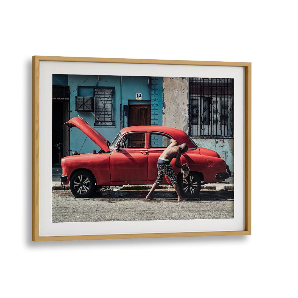 Man washing a red car on the street, showcasing WASHING A CAR, PHOTOGRAPHY PRINTS from Oakwood Mount.