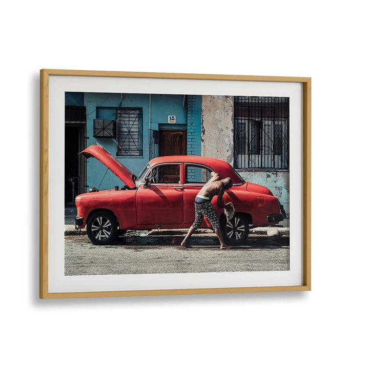 Man washing a red car on the street, showcasing WASHING A CAR, PHOTOGRAPHY PRINTS from Oakwood Mount.