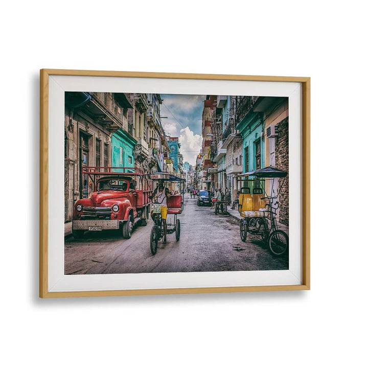 Colorful street scene featuring vintage cars and pedicabs from HABANA STREET XII, PHOTOGRAPHY PRINTS collection.