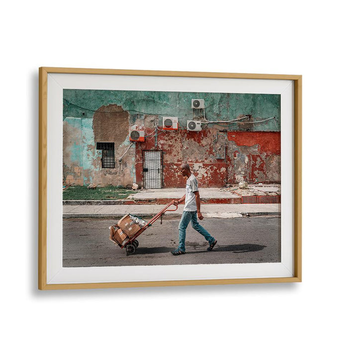 Urban scene featuring a man with a cart, perfect for WALL , PHOTOGRAPHY PRINTS that capture city life vibrancy.
