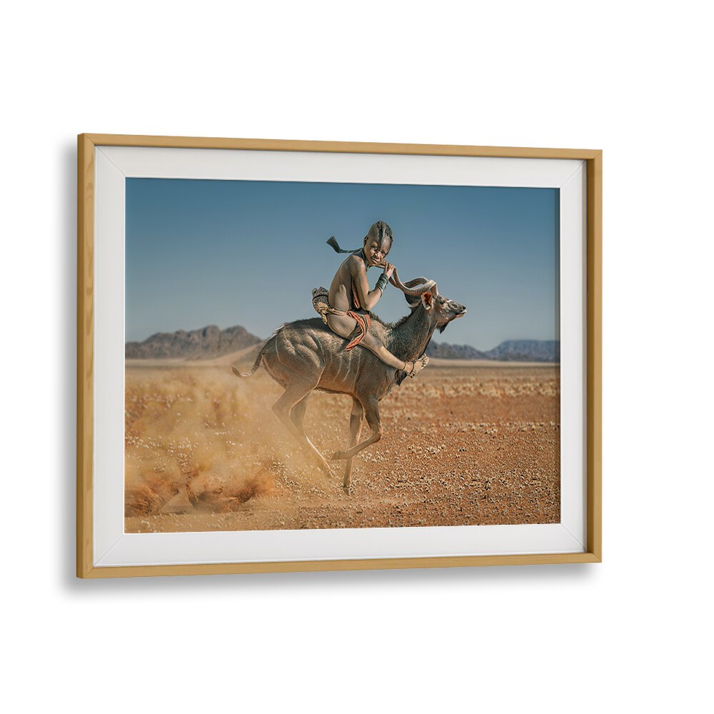 EASY RIDER, PHOTOGRAPHY PRINTS showcase a child riding a kudu, capturing wildlife's beauty and adventure.