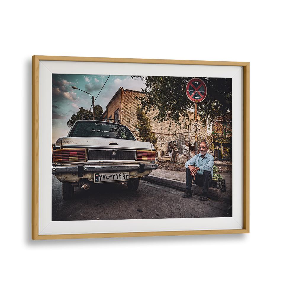 Captivating street scene in Shiraz featuring a man beside a vintage car from the STREETS OF SHIRAZ, PHOTOGRAPHY PRINTS series.