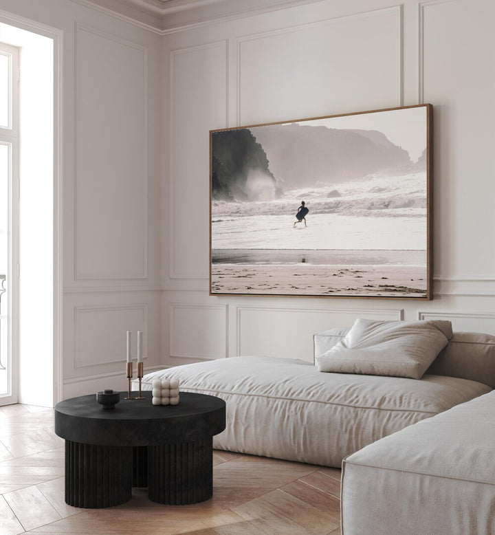 Oceans Call Beach Prints Coastal Wall Art in Oak Wood Floater Frame placed on a wall behind a sofa