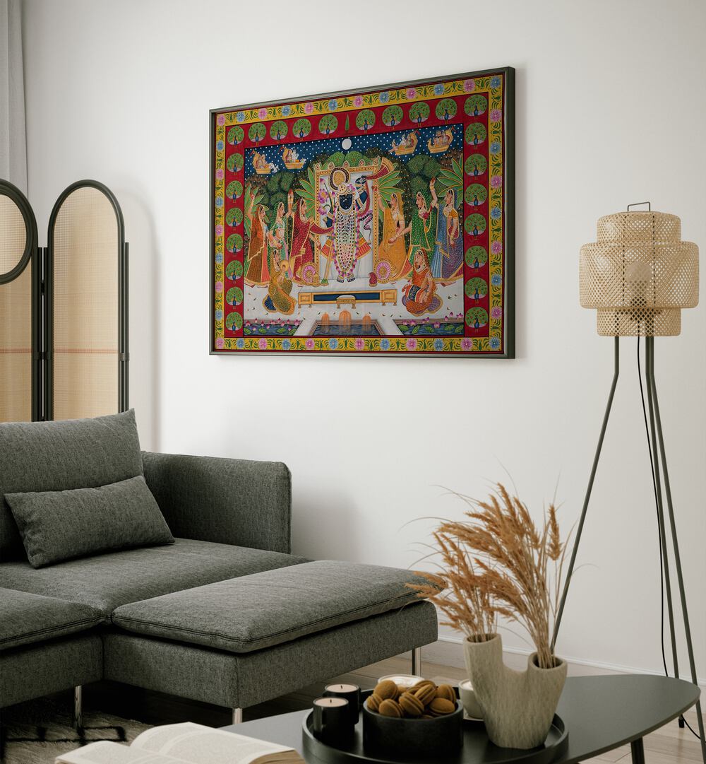 Pichwai Art VI Indian Art Painting Artwork in Black Plain Frame placed on an off white colored wall next to a grey sofa in the living room