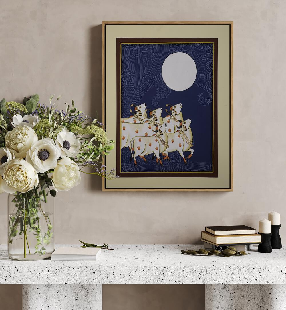 Pichwai Paintings III Artwork Indian Art Painting Artwork in oakwood floater frame above a white table on a beige wall