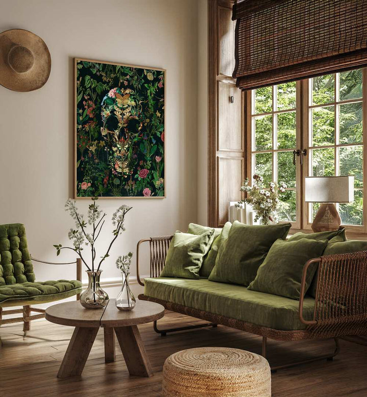 Papillon Skull Botanical Art Prints Floral Paintings in Oak Wood Plain Frame placed on a living room wall beside a green sofa and window