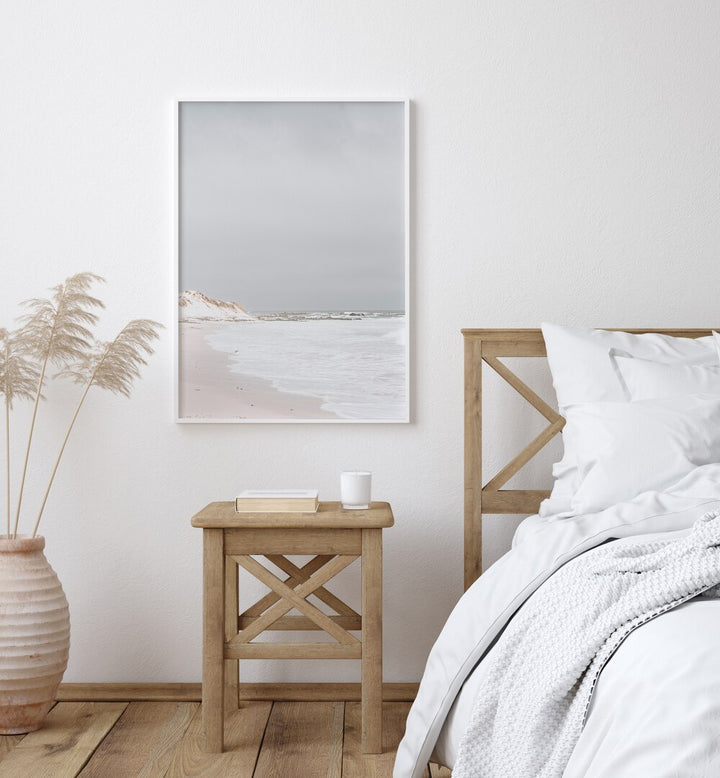 Pearlescent Momentum Beach Prints Coastal Wall Art in White Plain Frame placed on a White Colored Wall near a Bed in the Bedroom