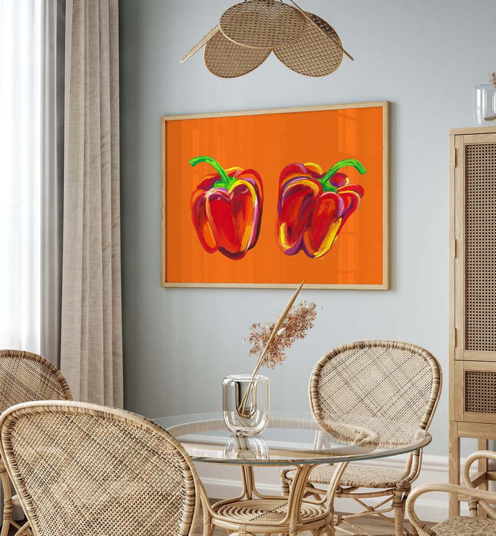 Peppers On Orange by Alice Straker Kitchen Posters Kitchen Art Prints in Oak Wood Plain Frame placed on a wall in a dining room area beside a window and behind a dining table