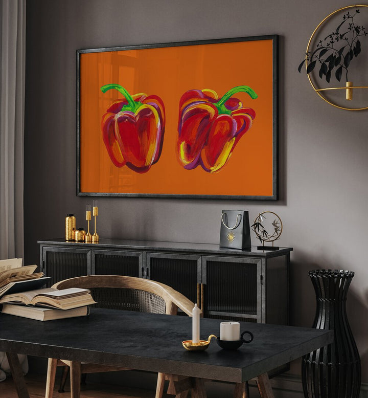 Peppers On Orange by Alice Straker Kitchen Posters Kitchen Art Prints in Black Plain Frame placed on a wall behind a black console table