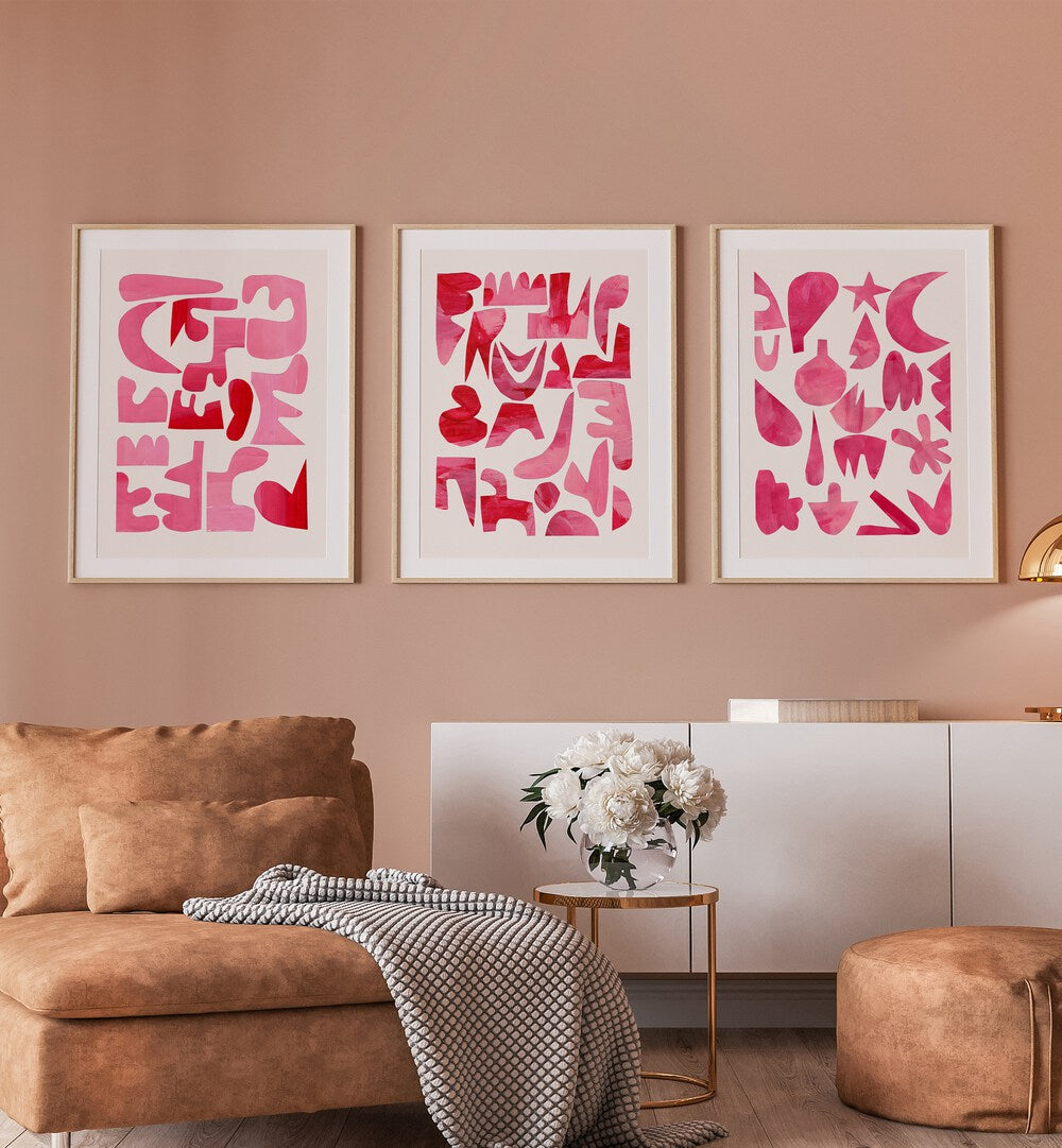 Pink Puzzles Set Set Of 3 Paintings in Oak Wood Frame With Mount placed on a wall behind a console table and a sofa