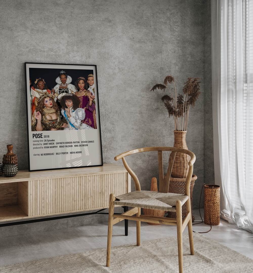 Pose 2018 Movie Posters in Black Plain Frame placed on a table beside oakwood chair