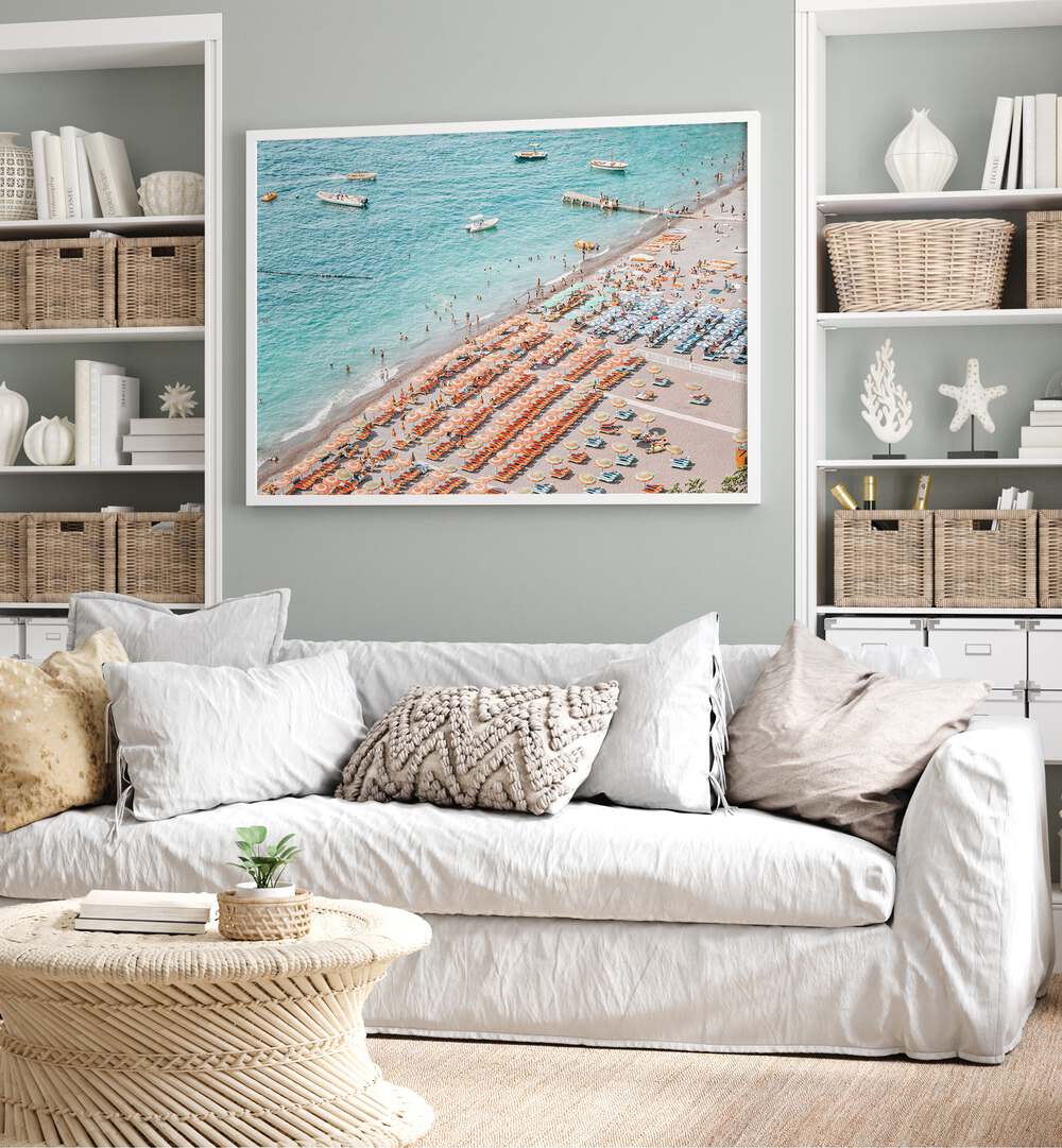 Positano Beach By Grace Digital Art Co Beach Prints in White Plain Frame placed on a wall behind a sofa