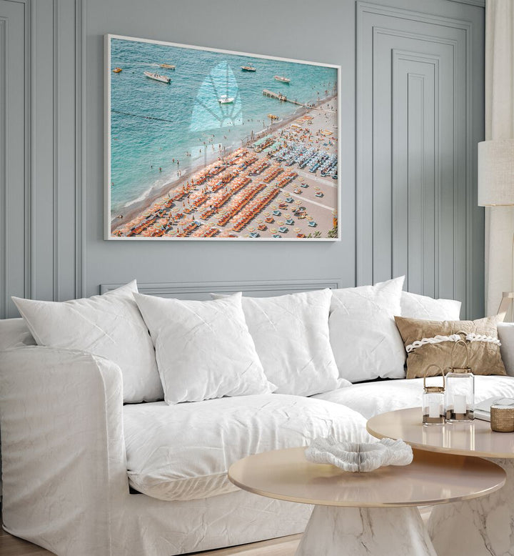 Positano Beach By Grace Digital Art Co Beach Prints in White Plain Frame placed on a wall behind a sofa for living room