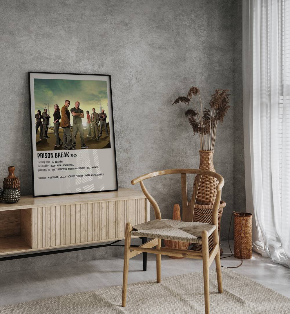 Prison Break 2005 Movie Posters in Black Plain Frame placed on a table beside oakwood chair