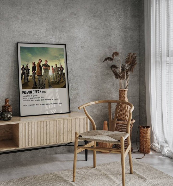 Prison Break 2005 Movie Posters in Black Plain Frame placed on a table beside oakwood chair