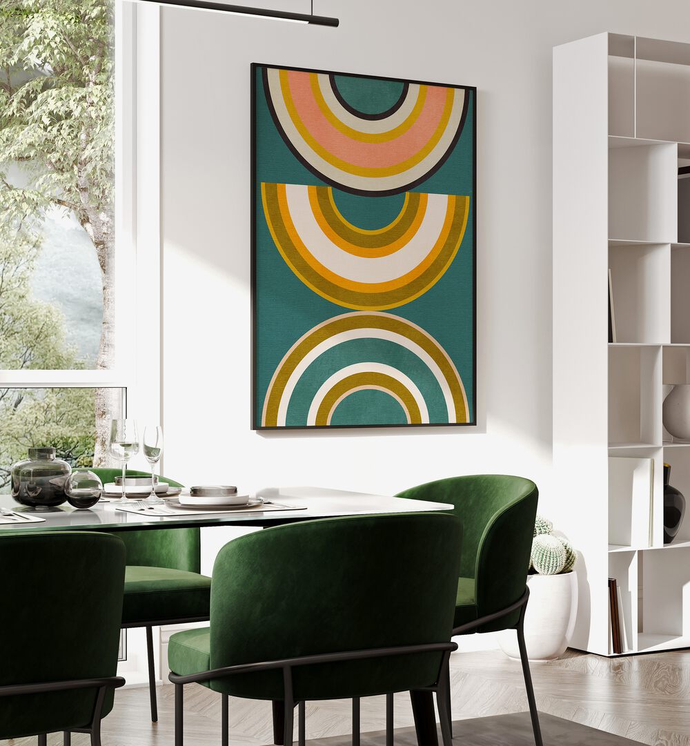 Rainbow Suns V Kopie By Ana Rut Bre Abstract Art Abstract Wall Art in Black Plain Frame placed on a wall behind a dining table 