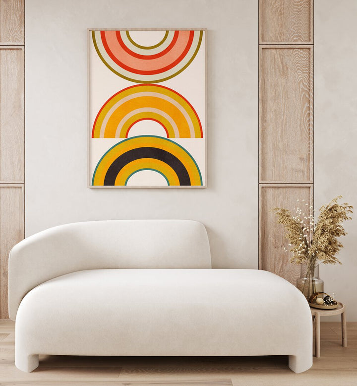 Rainbow Suns Vi By Ana Rut Bre Abstract Art Abstract Wall Art in Oak Wood Plain Frame placed on a wall behind a sofa