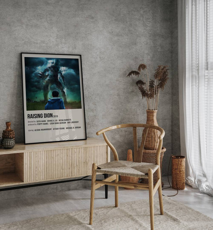 Raising Dion 2019 Movie Posters in Black Plain Frame placed on a table beside oakwood chair