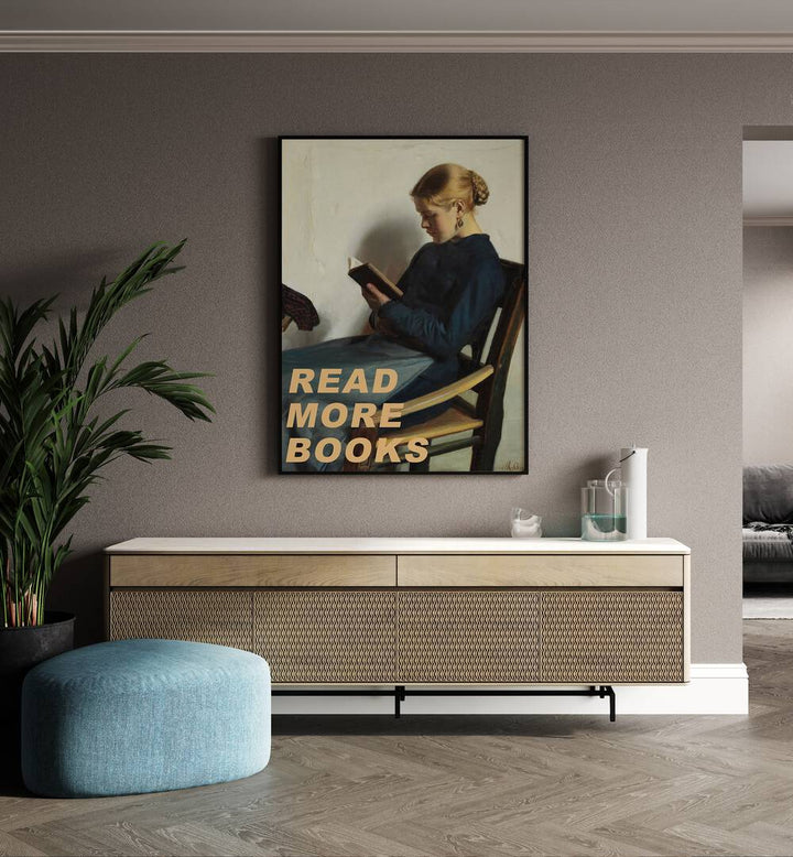 Read More Books by the Art Concept Altered Art Prints in Black Plain Frame placed on a wall behind a console table