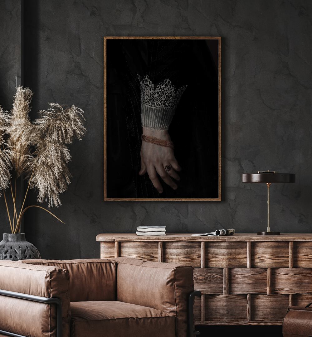 Regal Grasp The Royal Gothic Hand Gothic Art Prints in Oak Wood Plain Frame hanging on wall above brown chair beside plant.