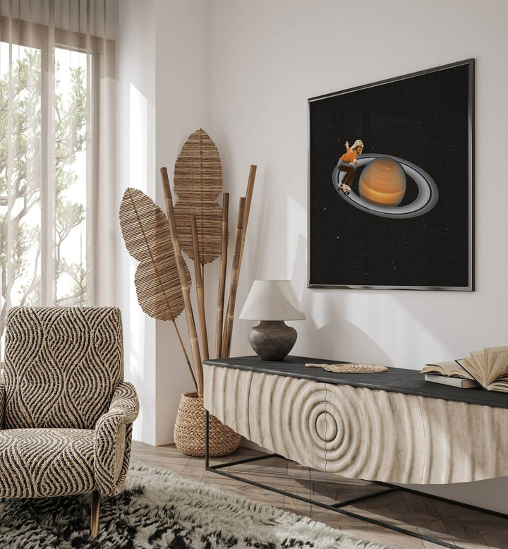 Saturn Skating -Skateboard Surreal Art Painting Artwork in plain black frame above a console table beside an artificial plant