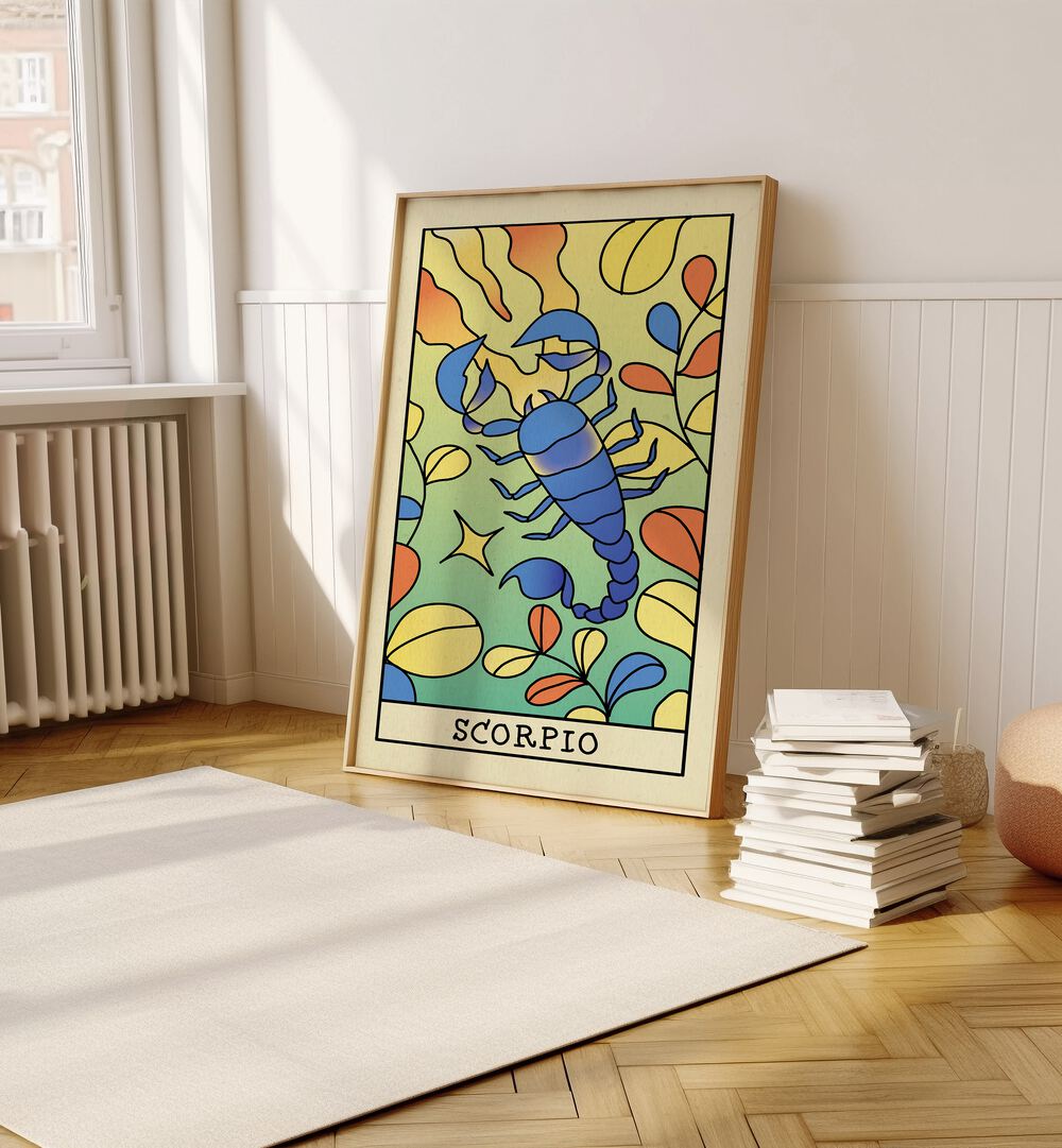 Scorpio Zodiac & Tarot Art Painting Artwork in plain oakwood frame on a wooden floor beside a stack of books