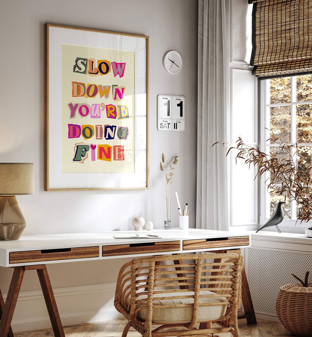 Colorful wall art featuring the phrase "SLOW DOWN YOU'RE DOING FINE" enhances a serene workspace ambiance.