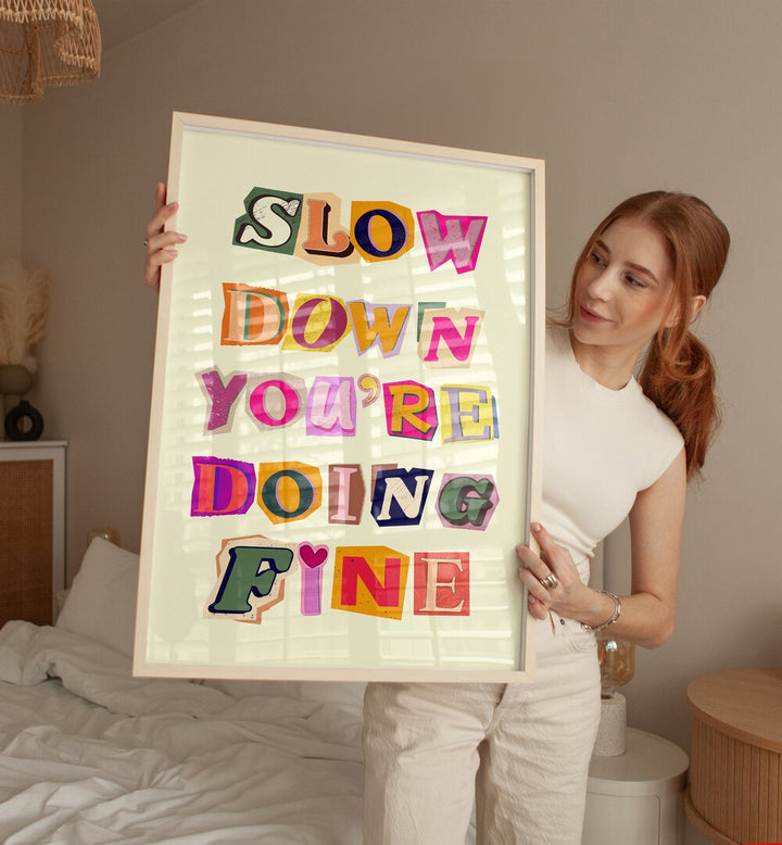 Framed artwork displaying the phrase "SLOW DOWN YOU'RE DOING FINE," perfect for home decor inspiration.