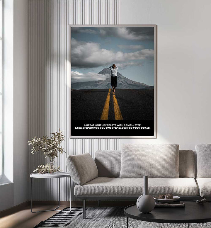 SMALL STEPS , QUOTES poster decor on wall in a modern living room with a couch and mountain backdrop.
