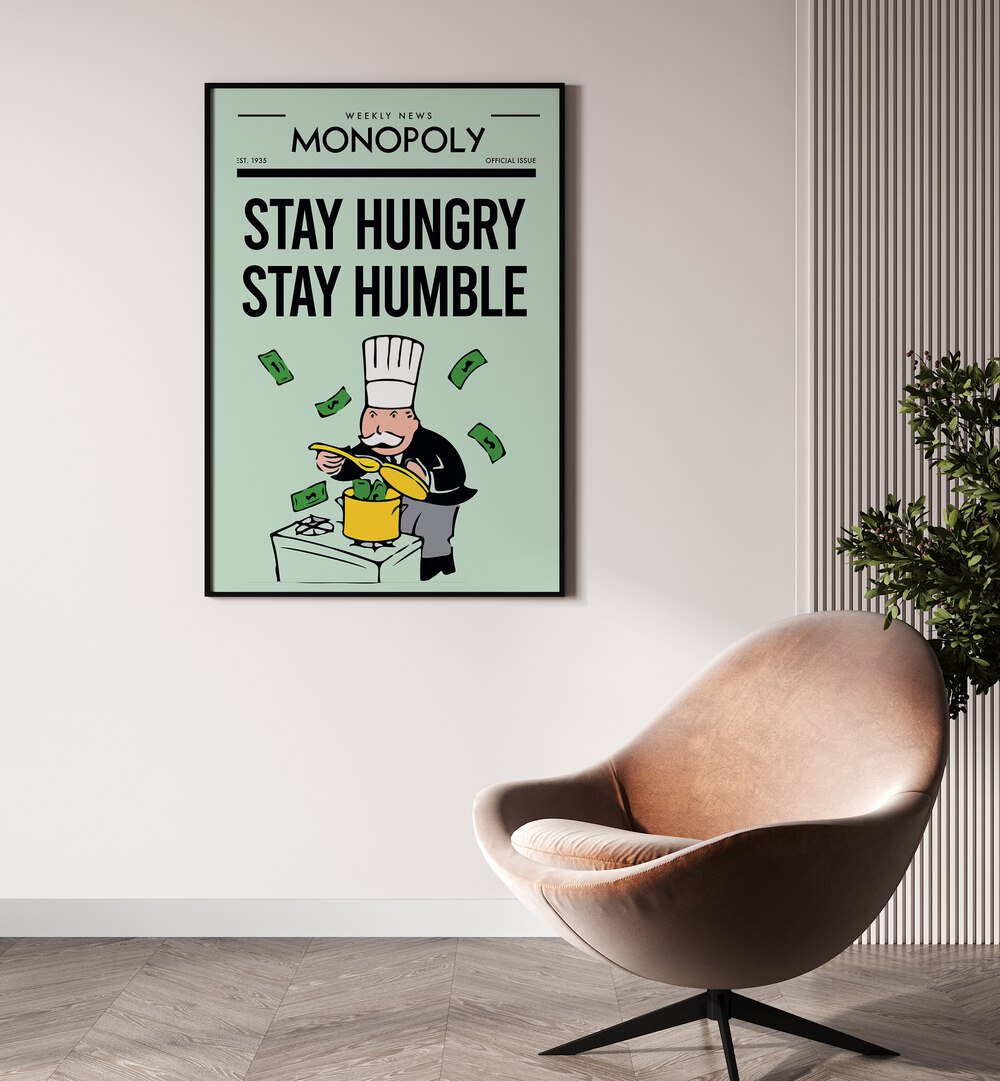 Stay Hungry Stay Humble Money Art Artwork in plain black frame hanging on wall near chair in sitting space