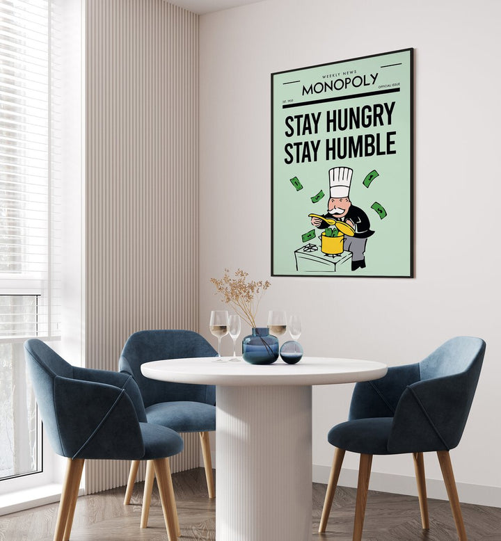 Stay Hungry Stay Humble Money Art Artwork in plain black frame hanging on wall near blue dining table