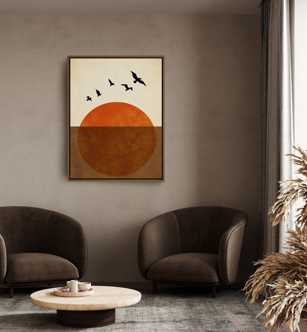 Sunset Dreams Landscape Art Artwork in Oak Wood Floater Frame Placed on a Dark Beige Wall near Brown Sofa Chairs in the Living Room