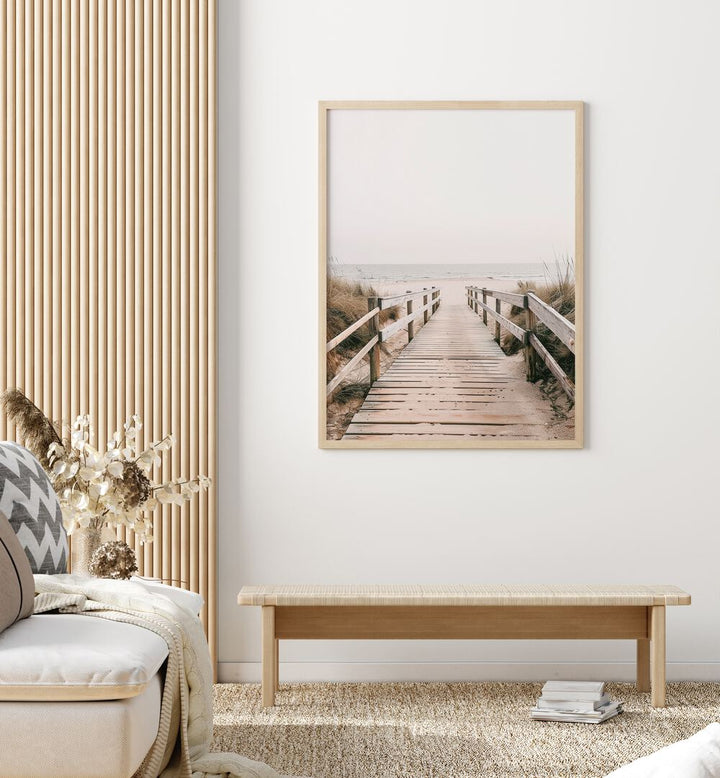 Sandy Promenade Beach Prints Coastal Wall Art in Oak Wood Plain Frame placed on a White Colored Wall in the Living Room